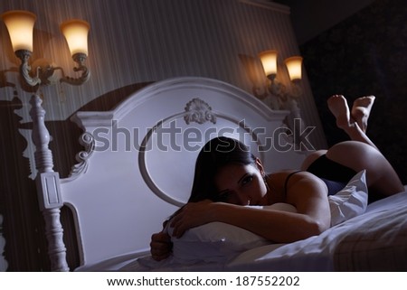 Super sexy woman laying in seductive pose on the bed