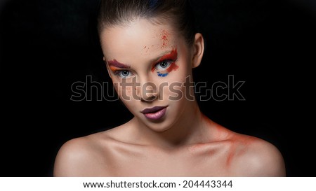 Bright colors on her face, amazing girl. poses in studio on black background