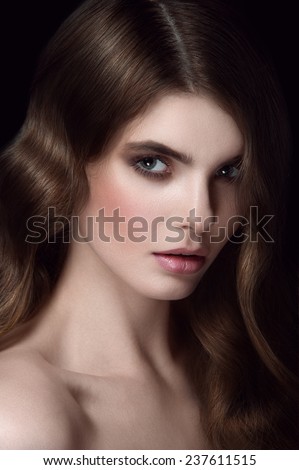 Beauty portrait of young girl with chestnut head, big green eyes, pouty lips with natural lipstick, gap in teeth and curls falling on her eye with face turned up and to the right looking at you