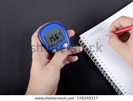 Dependent first type Diabetic patient measuring glucose level blood test using ultra mini glucometer and small drop of blood from finger and test strips isolated on a white background