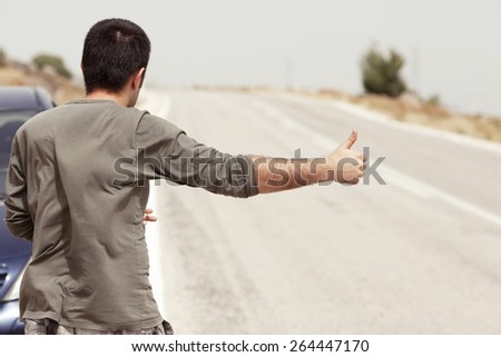 Man Hitchhiking on a Country Road