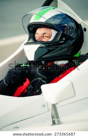 driver in race car adjust helmet before race
