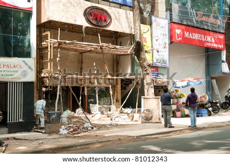 BANGALORE, INDIA - MAY 17: Unidentified men stand near the construction of a new restaurant on May 17, 2011 in Bangalore, India. Rising disposable incomes have resulted in a retail boom in India.