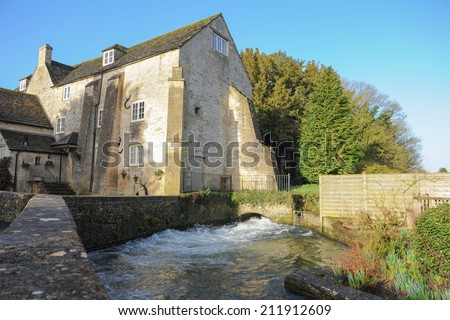 The Water Mill in the famous Cotswold village of Bibury, popular with tourists, situated on the River Coln in the county of Gloucestershire, England, UK