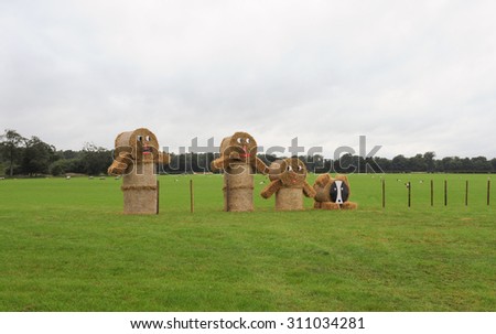 A Family of Scarecrows made from Straw Bales in a Field with Sheep in Knutsford, Cheshire, England, UK