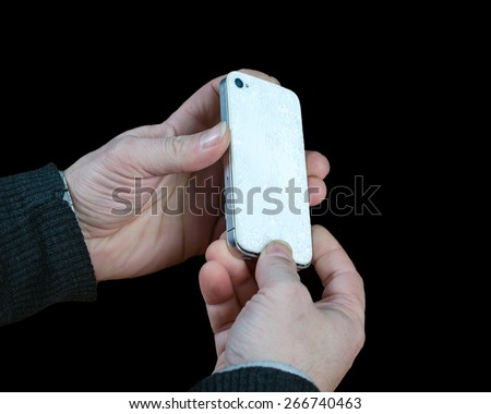 Serviceman opening a broken cell phone isolated on black background