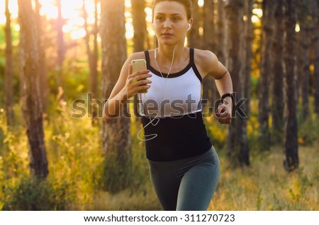 Runner athlete running on forest trail. woman fitness jogging workout wellness. Soft Focus, low light in shade, grain texture visible on maximum size