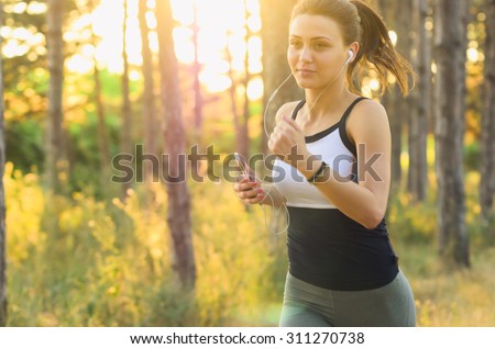Runner athlete running on forest trail. woman fitness jogging workout wellness. Soft Focus