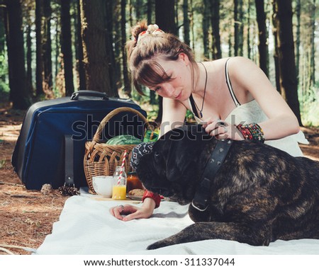 Girl on picnic with her dog. Vintage Instagram style effect, soft and selective focus, grain texture visible on maximum size