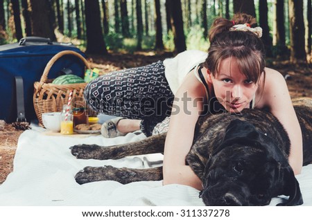 Girl on picnic with her dog. Vintage Instagram style effect, soft and selective focus, grain texture visible on maximum size