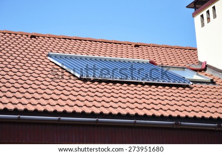 Closeup of vacuum solar water heating system on the red tiled house roof
