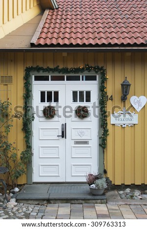 The grey house door in the old yellow wooden wall
