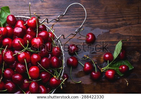 Cherries on wooden table with water drops
