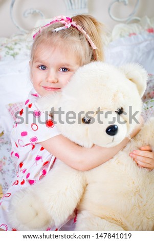 The girl on the bed with a big bear