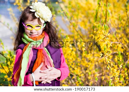 Beautiful girl in funny glasses in yellow flowers