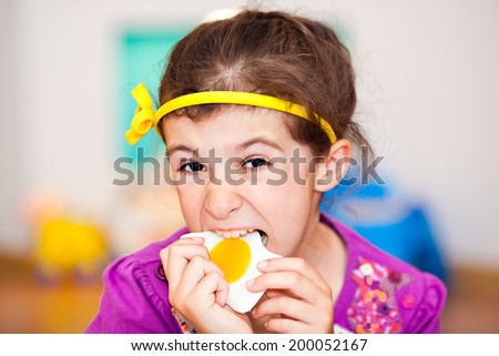 Child bites and eats fried egg