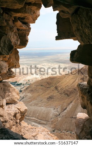 View on coast of the Dead Sea through a breach in a wall of stability Masada, Israel