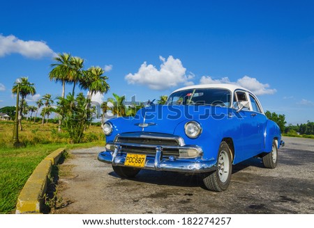 TRINIDAD, CUBA - DECEMBER 8, 2013: Typical view of classic blue American car on Cuban where old vehicles become iconic part of Cuba landscape after Revolution in 1960s.