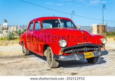 HAVANA, CUBA - DECEMBER 2, 2013: Old classic American red car parked in the old town of Havana, near Malecon (Avenida de Maceo)