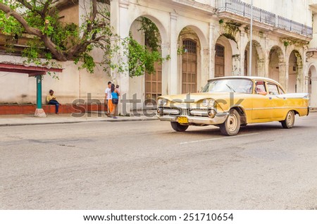 HAVANA, CUBA - DECEMBER 2, 2013: Classic American yellow car one of streets in Havana, where old cars bought before Cuban revolution are icon view of Cuba