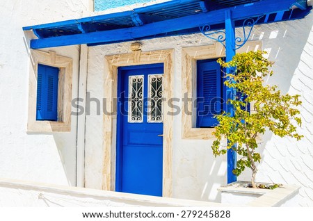 Iconic view on wooden blue doors and windows with shade from roofing typical for Greece