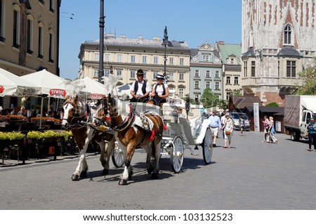 KRAKOW, POLAND - MAY 20: Horse-drawn carriage at City Square on May 20, 2012 in Krakow, Poland. Horse-drawn carriage tour of Krakow is a great attraction for tourists from around the world.