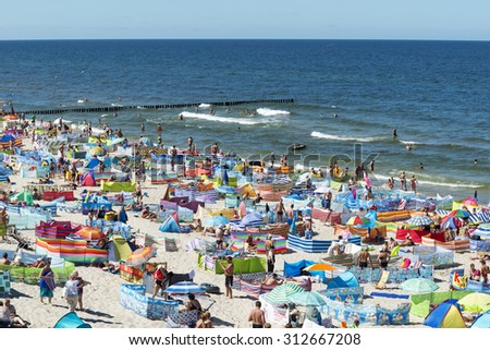 REWAL - AUGUST 13: Tourists enjoy the sunny weather and relaxing on the Baltic sea beach on 13 August 2015 in Rewal, Poland.