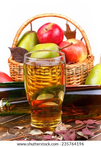 Glass and bottles of cider, fruits basket with apples and pears