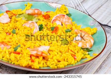 Plate of Shrimps Risotto garnished with fresh parsley and red chili pepper
