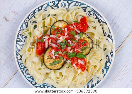 Tagliatelle pasta with grilled eggplant, spicy tomato sauce and parmesan cheese