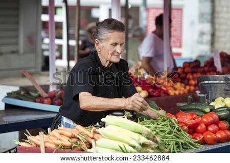 Split - Croatia - August 25, 2014 Elderly woman sells vegetables at a market in Split, Croatia