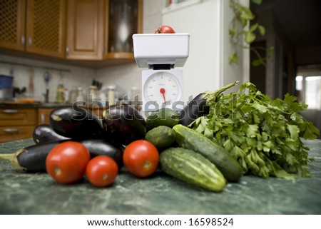 white kitchen scale and vegetable cucumber and tomato