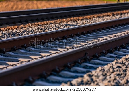 Similar – Foto Bild Gleisbett einer wenig benutzten Bahnstrecke, am Rand kahle Bäume. Schwarzweiß-Aufnahme.