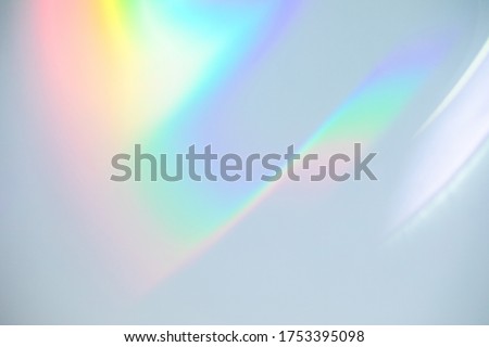 Blurred rainbow light refraction texture overlay effect for photo and mockups. Organic drop diagonal holographic flare on a white wall. Shadows for natural light effects Foto stock © 