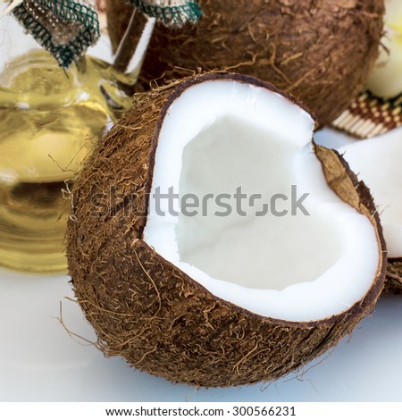 Close up  Half of Fresh coconut and part of bottle with coconut oil on the background