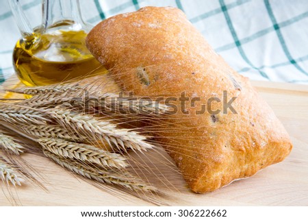 Italian bread Ciabatta with ears and olive oil on the wooden table
