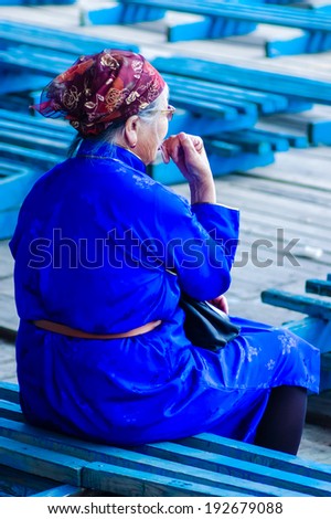 NADAAM OPENING CEREMONY, ULAANBAATAR, MONGOLIA - JULY 11, 2010: Woman in traditional tunic called a deel before Opening Ceremony of Nadaam, the most important festival of the year in Mongolia.