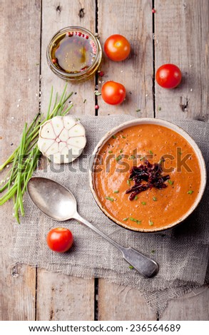 Tomato soup with sun dried tomatoes on a wooden background
