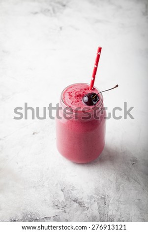 Cherry coconut milk, yogurt and honey smoothie on a stone background