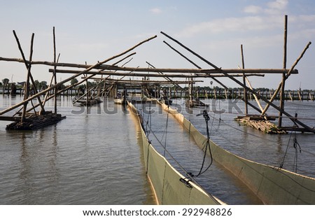 Fishing facilities Tonle Sap. Quite a large lake in Cambodia - Tonle Sap. It has built large fishing facilities for fishing. Hundreds of meters of wooden logs laid in a slender chute for the grid.