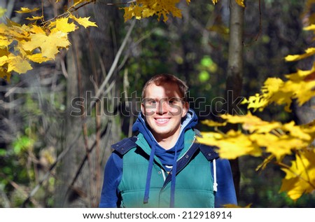 The cheerful guy in the autumn wood.
