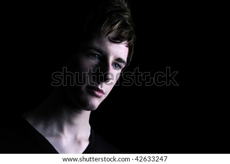 a young man in a dramatic setting with piercing blue eyes
