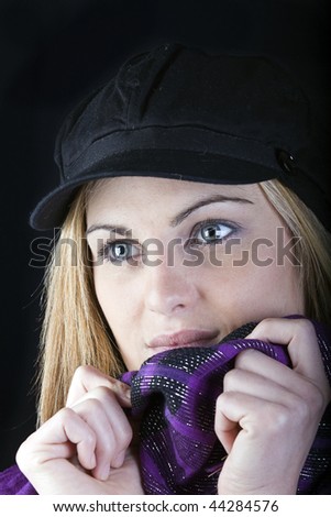 shy young blonde woman peeps out from her scarf