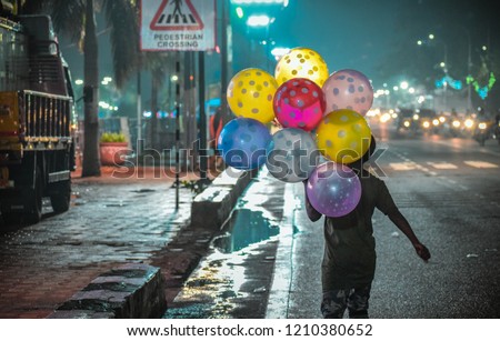 A poor child selling beautiful and colorful balloons on the street of Hyderabad to earn his living. Stock fotó © 
