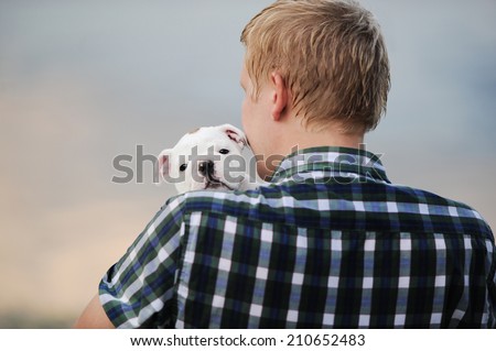 the man holds in hand of an puppy English bulldog
