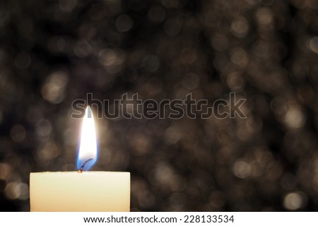 Burning white candle on abstract color background