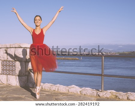 beautiful ballerina dancing smiling outdoors in a park,  sea at background, vintage