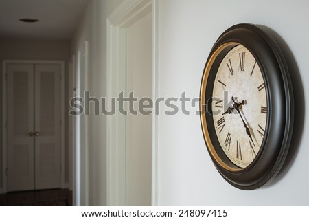 Wall clock on an off-white hallway wall.