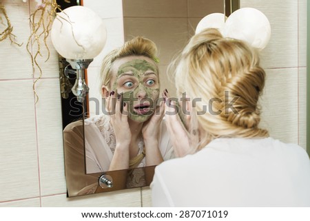 Girl puts a mask on his face in the mirror