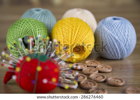 Sewing kit. Colored thread, pins, buttons, ribbons, safety pin.